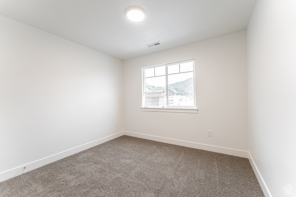 Unfurnished room with dark colored carpet