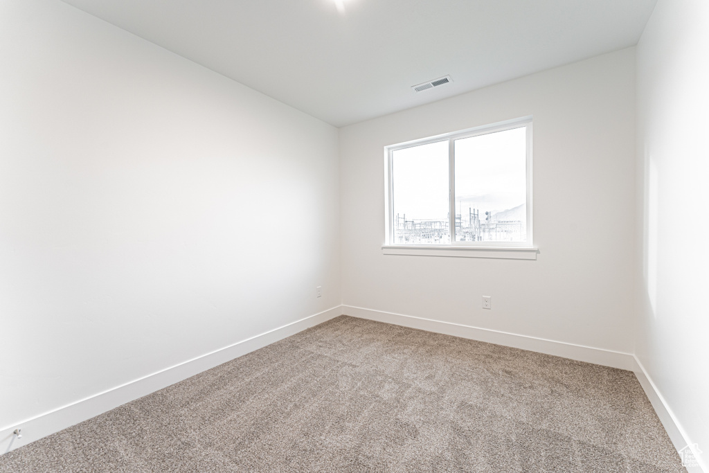 Carpeted spare room with baseboards