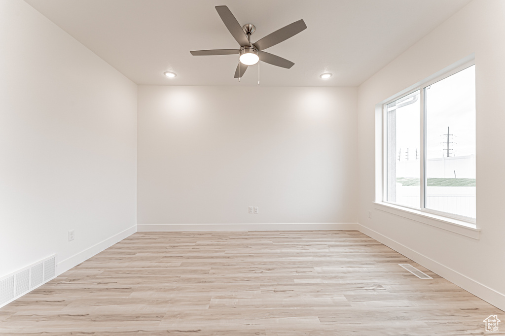 Empty room with a ceiling fan, light wood-style floors, and recessed lighting