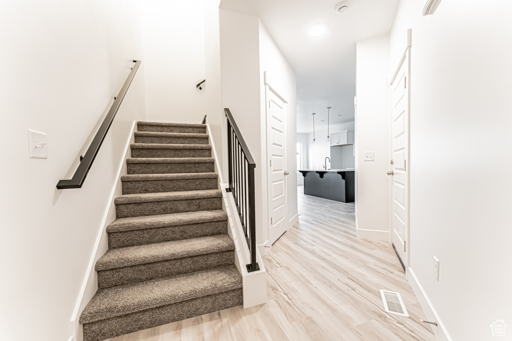 Stairs with baseboards and wood finished floors