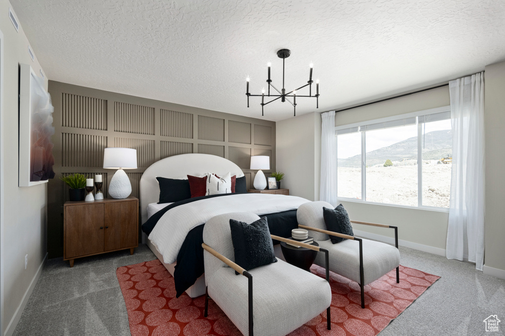 Bedroom with carpet, a notable chandelier, a textured ceiling, and baseboards