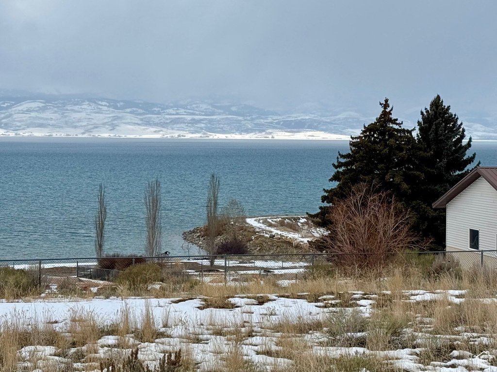 Water view featuring fence and a mountain view