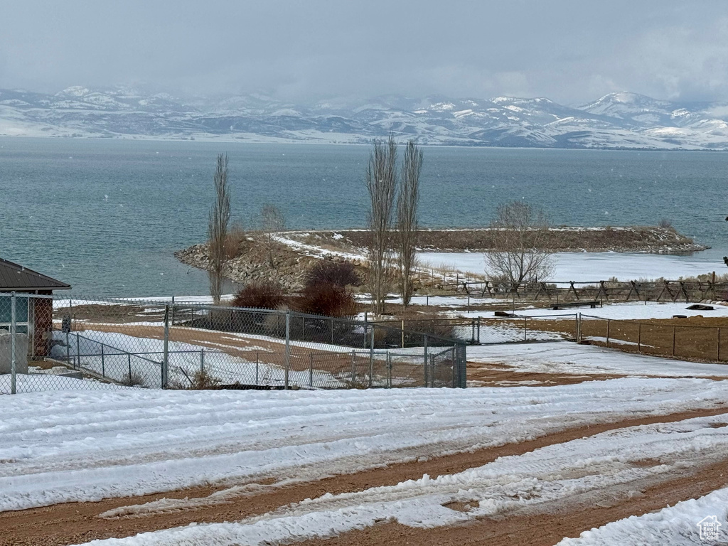 Water view with fence and a mountain view