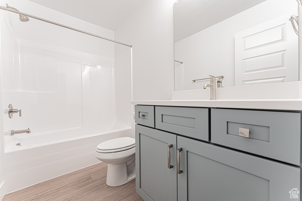 Bathroom featuring vanity, wood finished floors, and bathing tub / shower combination