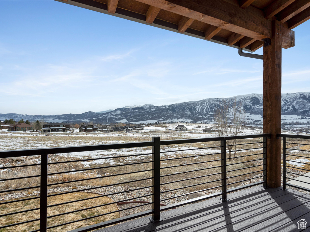 Snow covered back of property with a mountain view