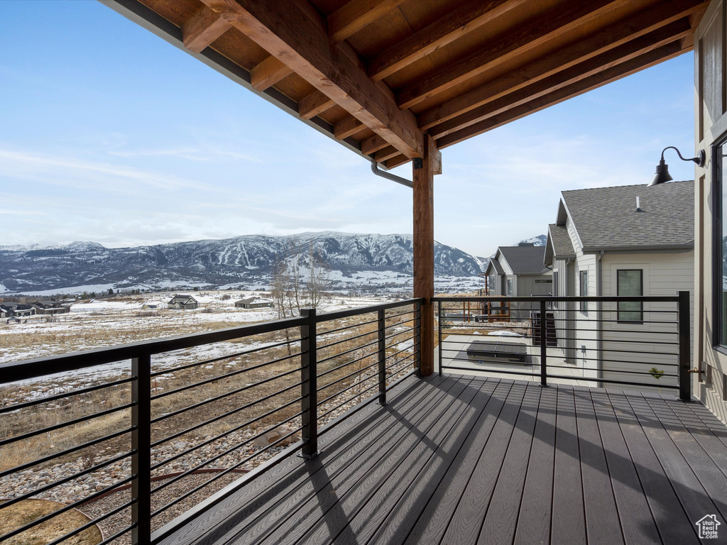 Snow covered deck with a mountain view