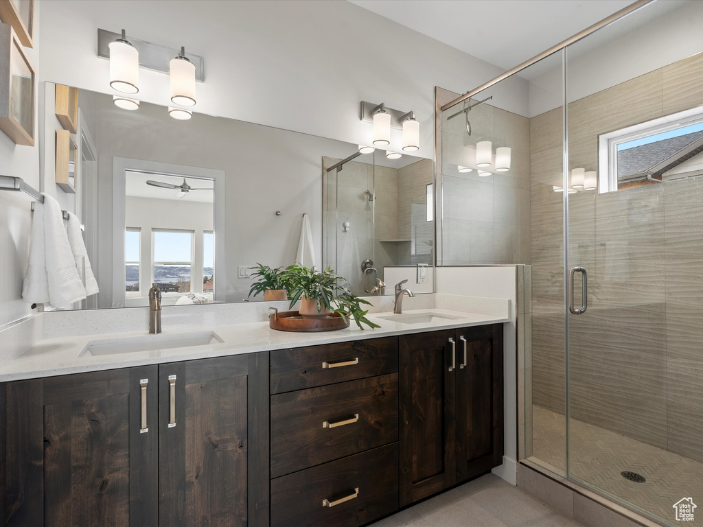 Bathroom with double vanity, a stall shower, and a sink