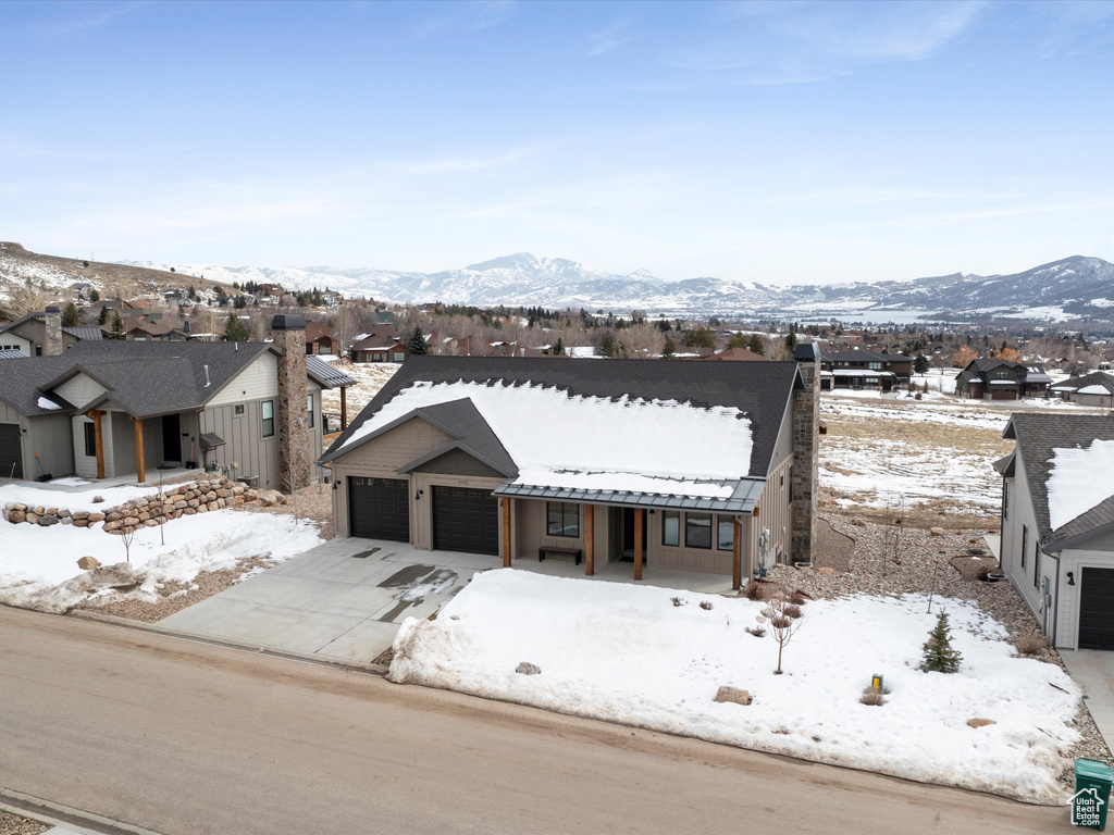 View of front of house featuring a residential view, covered porch, metal roof, and a mountain view