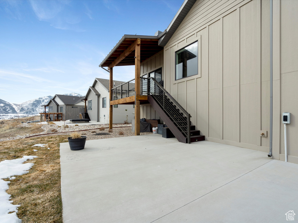 Exterior space with stairway, a patio area, and a mountain view