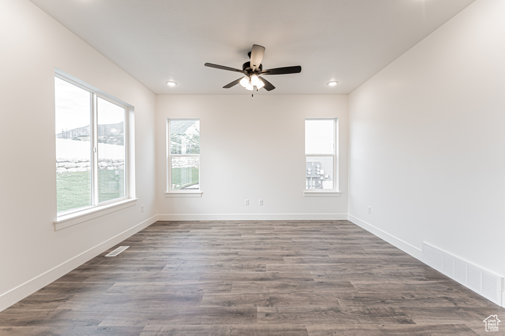 Spare room featuring a ceiling fan, recessed lighting, and dark wood finished floors