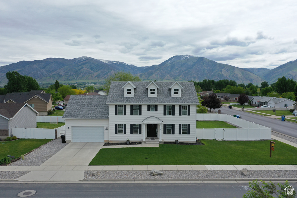 View of front of house with driveway, a garage, a mountain view, and a residential view