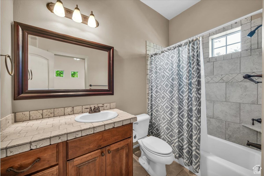 Bathroom with vanity, shower / tub combo, and tile patterned flooring