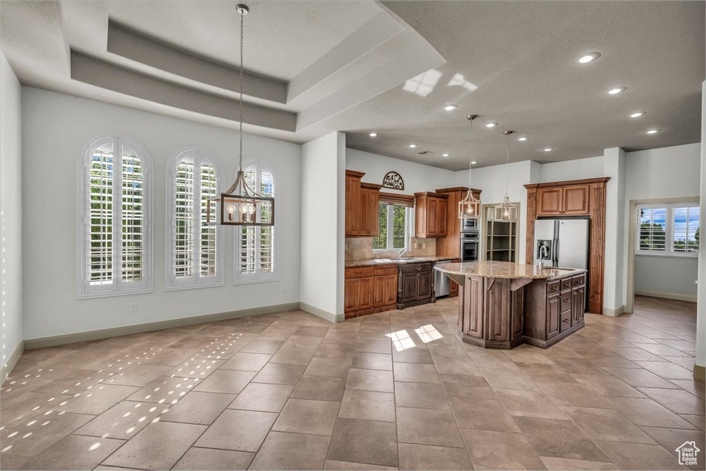 Kitchen featuring stainless steel appliances, healthy amount of natural light, recessed lighting, brown cabinets, and backsplash