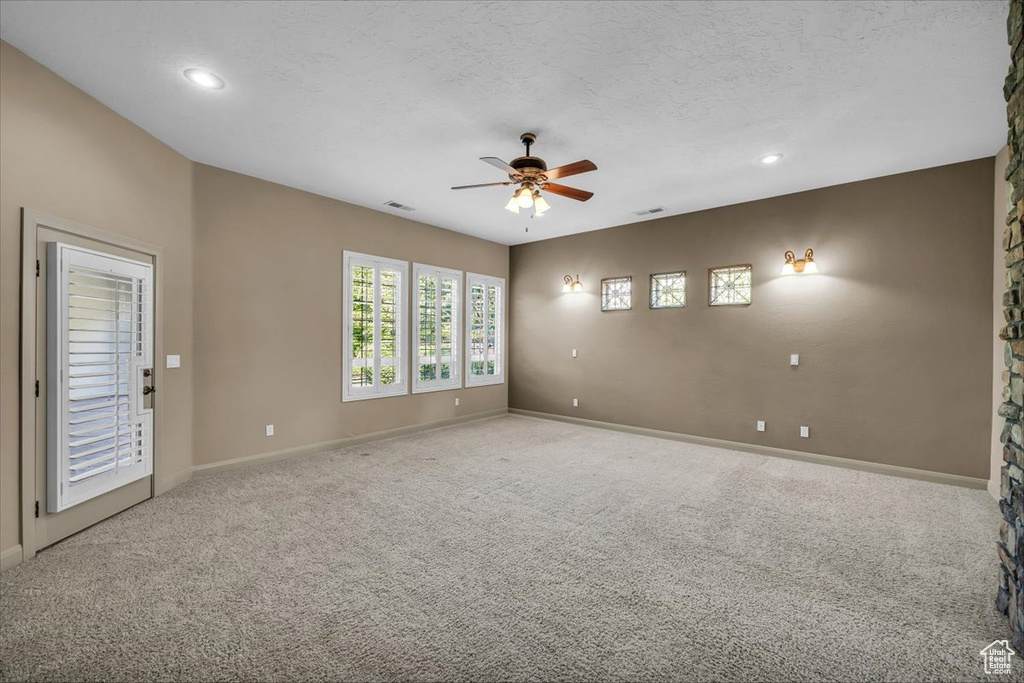 Carpeted spare room featuring a ceiling fan and recessed lighting