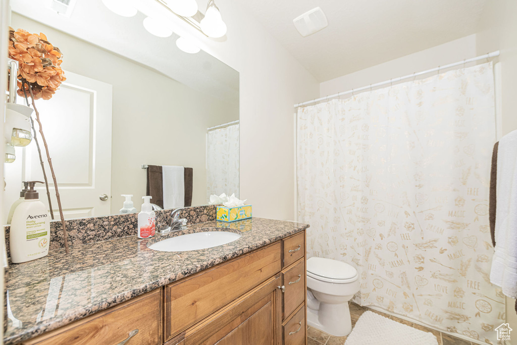 Full bathroom with toilet, tile patterned flooring, and vanity