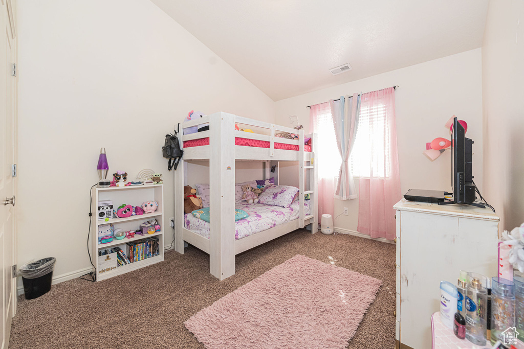 Bedroom with lofted ceiling, carpet, visible vents, and baseboards