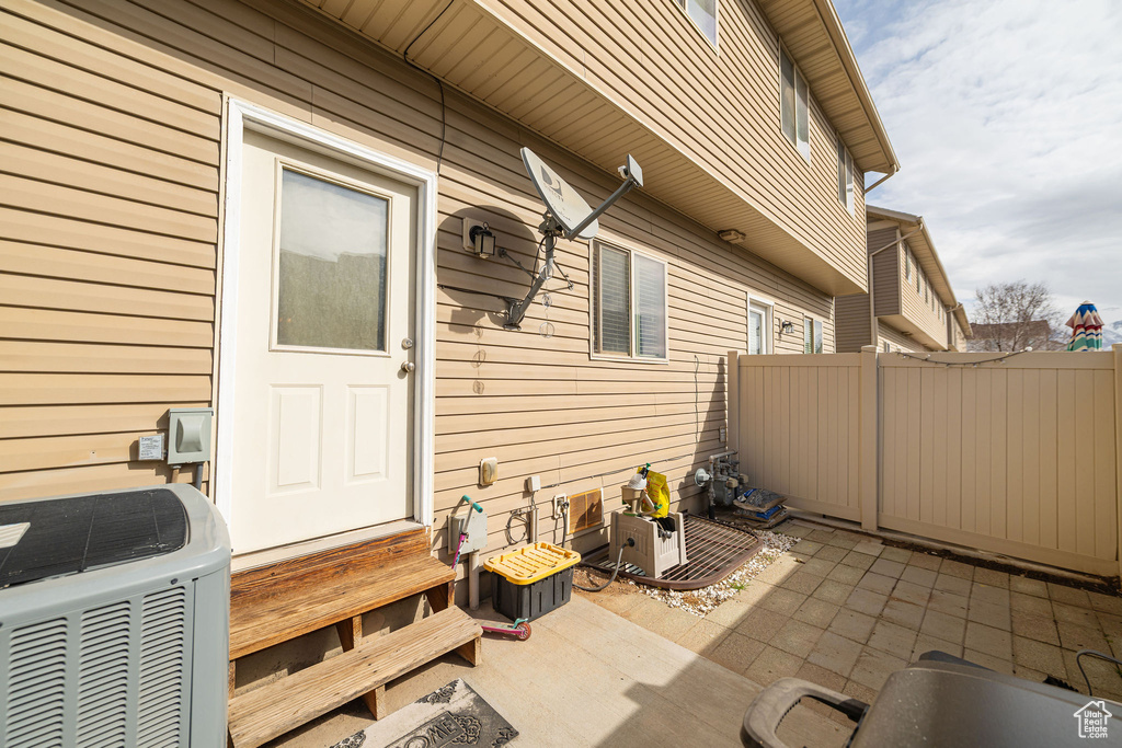 View of patio / terrace featuring entry steps, fence, and central air condition unit