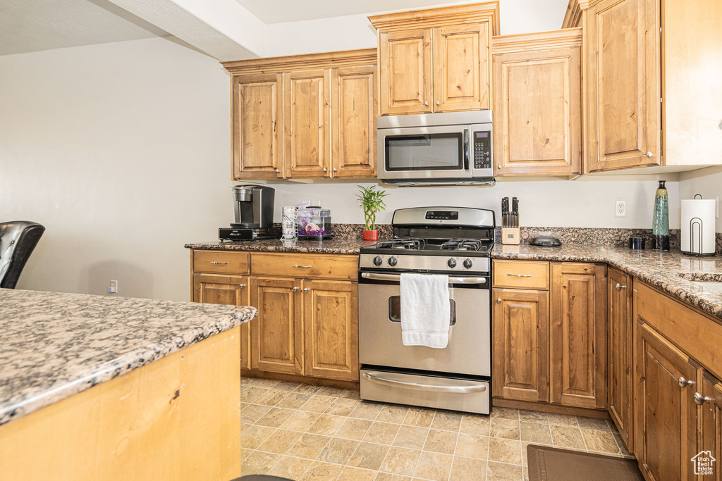 Kitchen featuring stainless steel appliances and light stone countertops