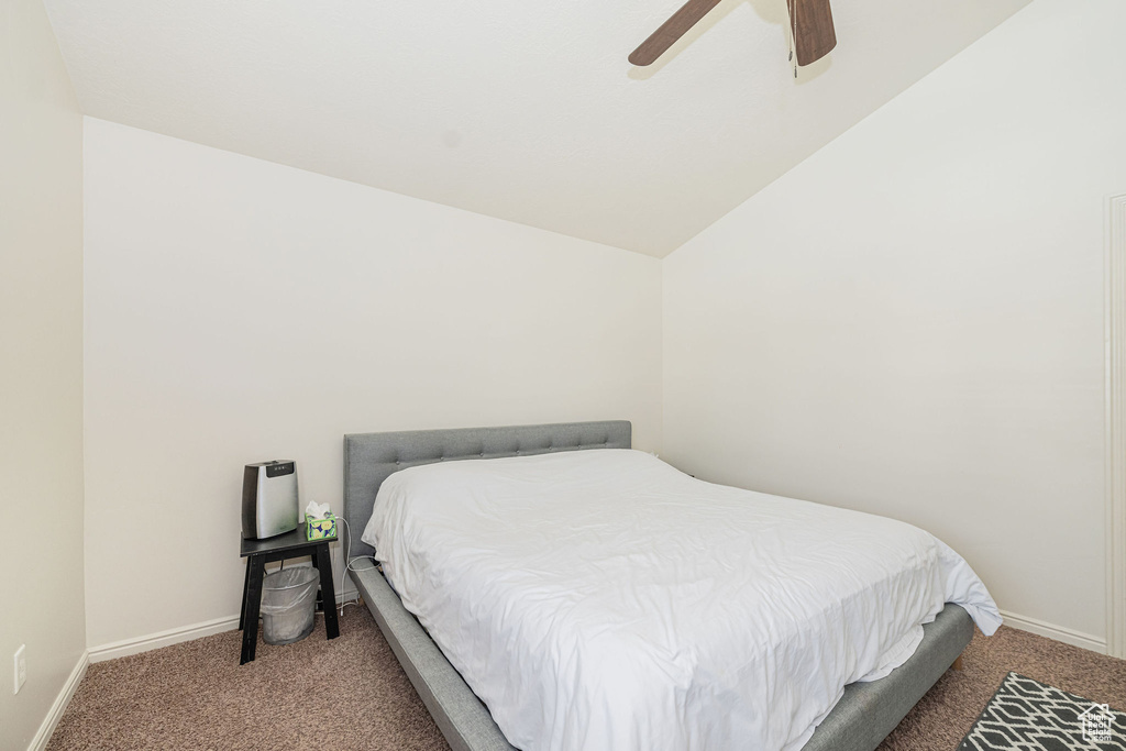 Bedroom with lofted ceiling, carpet flooring, a ceiling fan, and baseboards