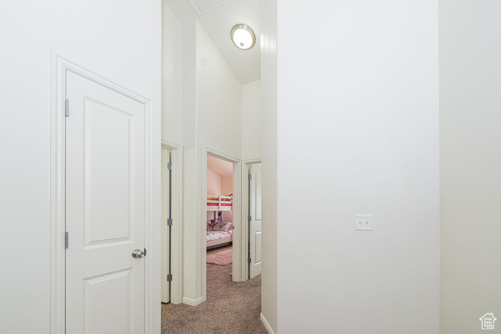 Hallway with carpet flooring and baseboards