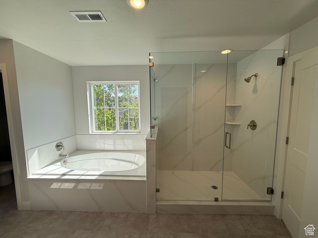 Bathroom with toilet, a bath, and a marble finish shower
