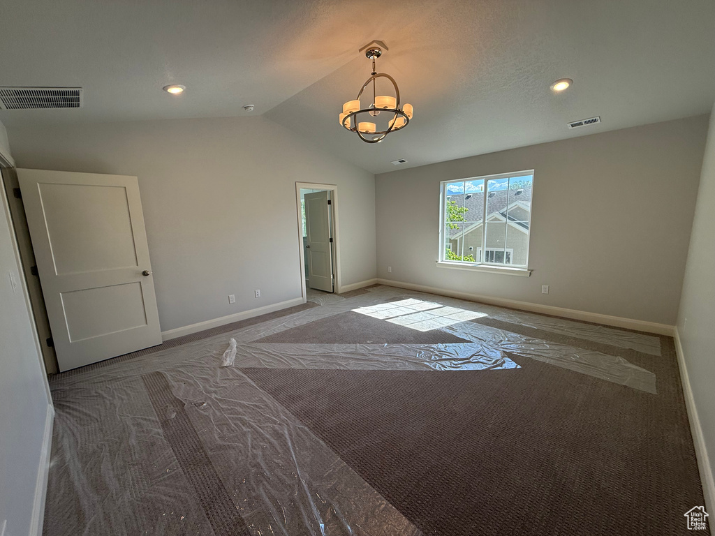 Carpeted empty room with a chandelier, lofted ceiling, baseboards, and recessed lighting