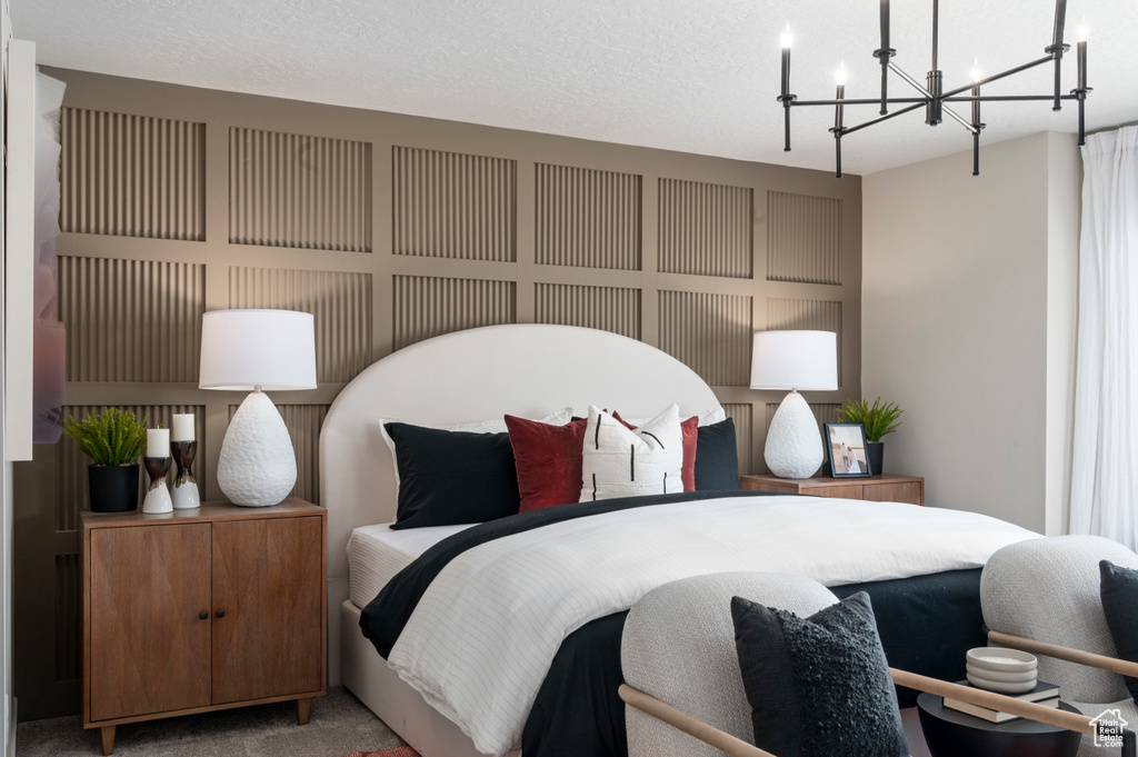 Carpeted bedroom with a textured ceiling and an inviting chandelier