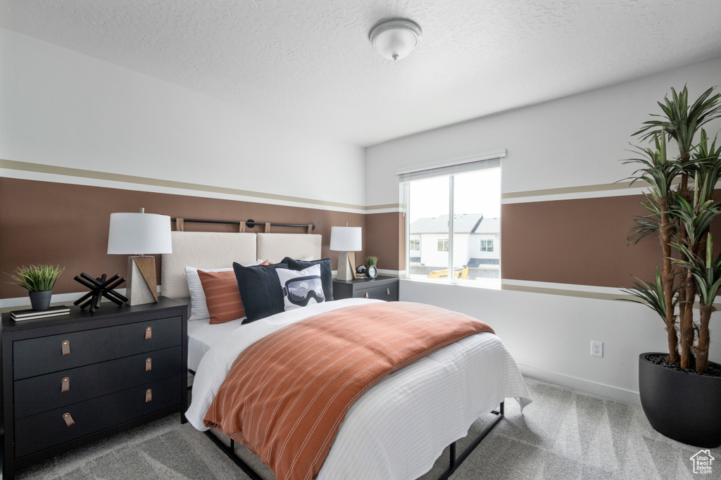 Carpeted bedroom with a textured ceiling and baseboards