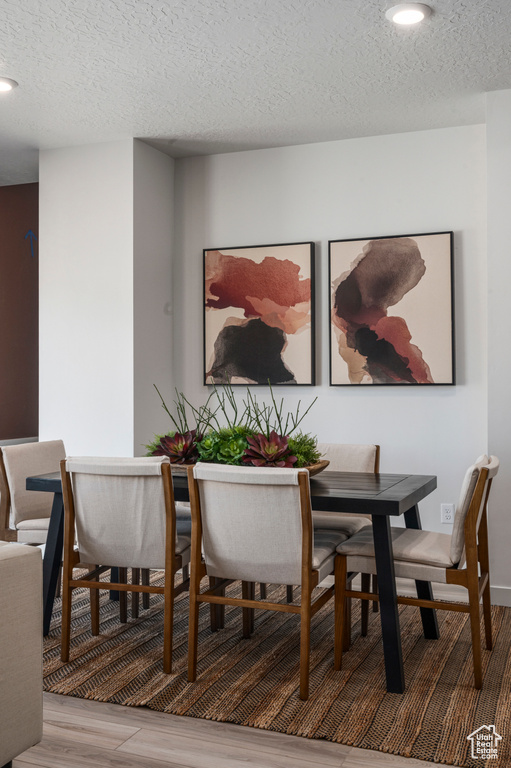 Dining space featuring a textured ceiling and light wood-style flooring