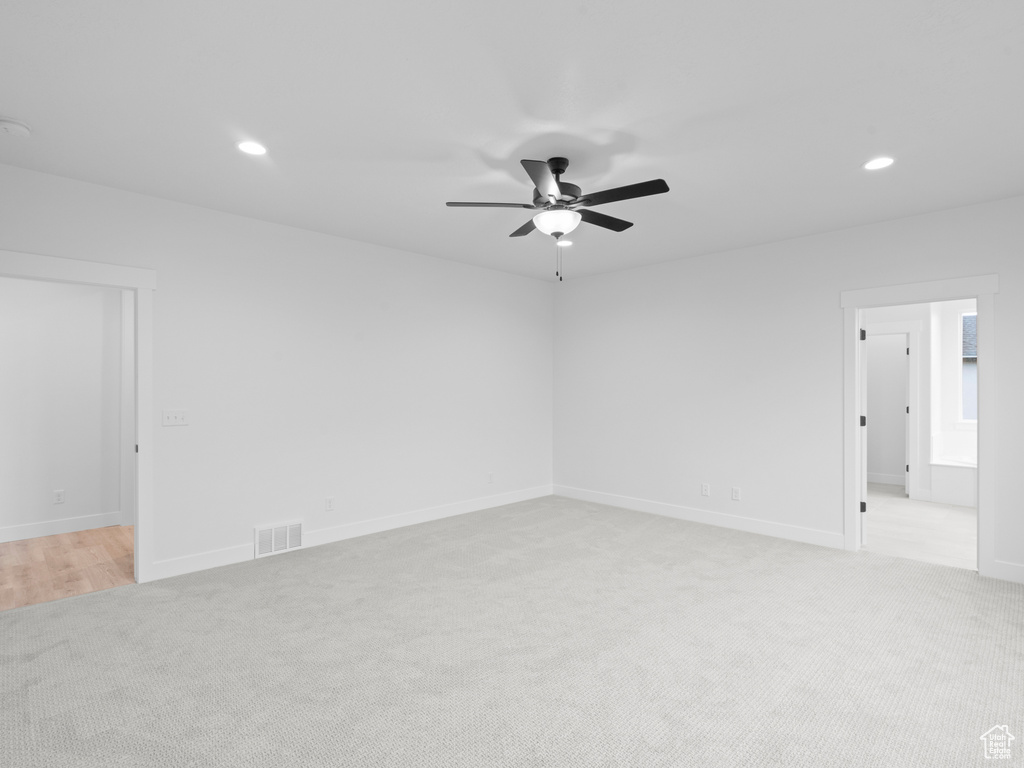 Unfurnished room with light carpet, visible vents, recessed lighting, baseboards, and a ceiling fan