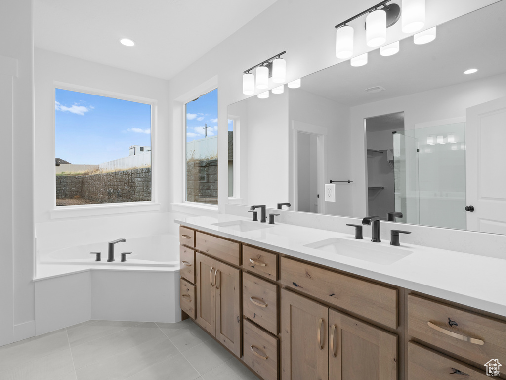 Full bath featuring a garden tub, tile patterned floors, a sink, and double vanity