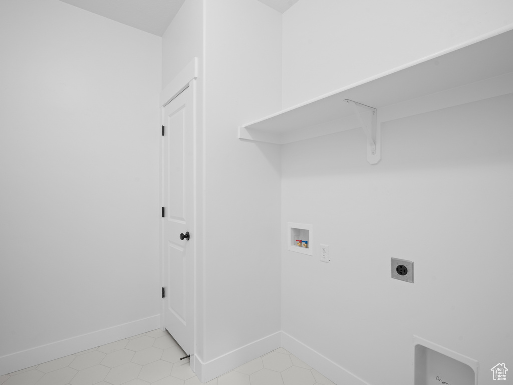 Washroom featuring baseboards, washer hookup, electric dryer hookup, laundry area, and light tile patterned floors