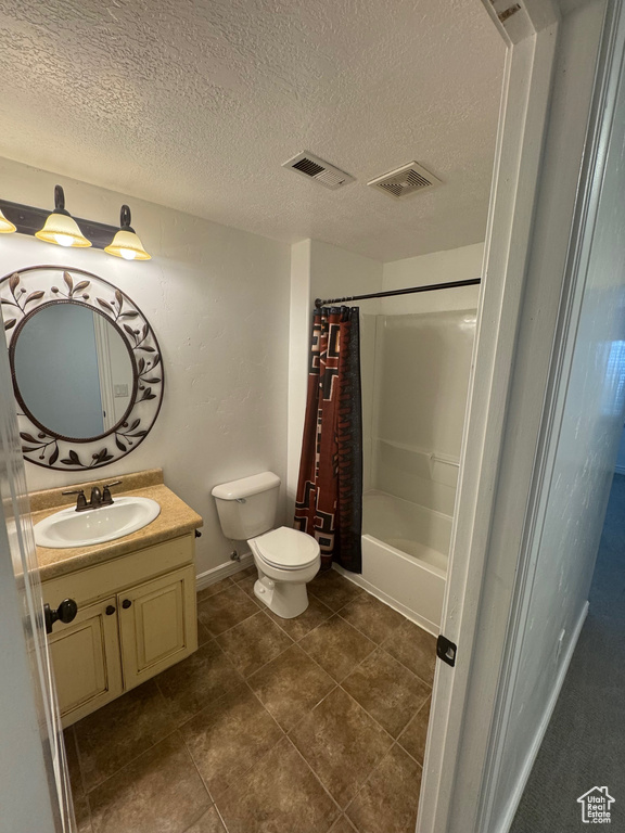 Full bathroom featuring toilet, visible vents, and a textured ceiling
