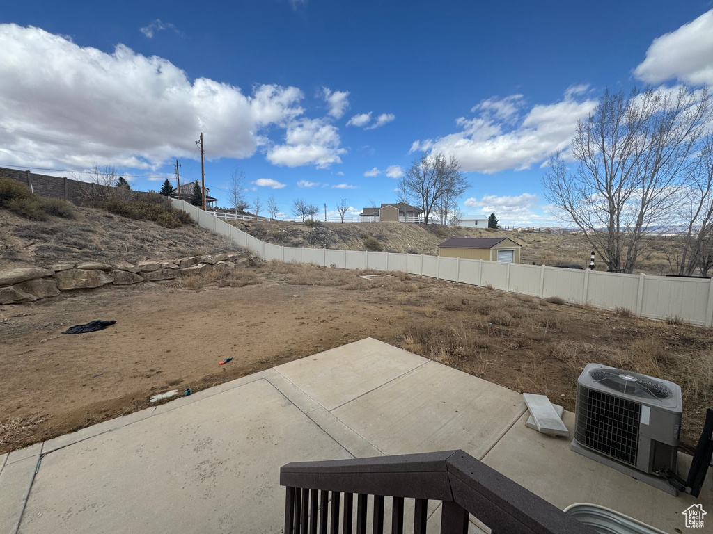 View of yard featuring a patio area, a fenced backyard, and cooling unit