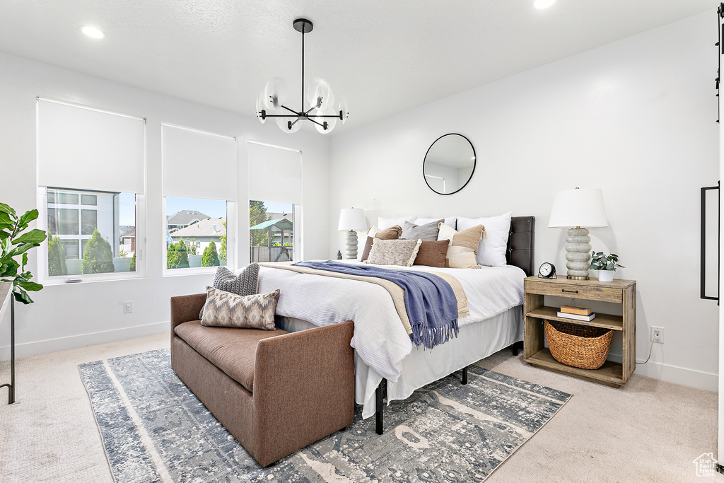 Carpeted bedroom with a chandelier and recessed lighting