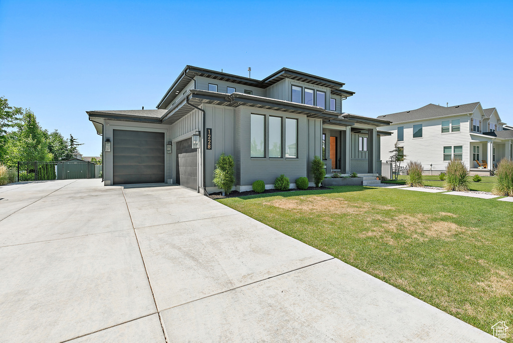 View of front facade with driveway, an attached garage, and board and batten siding