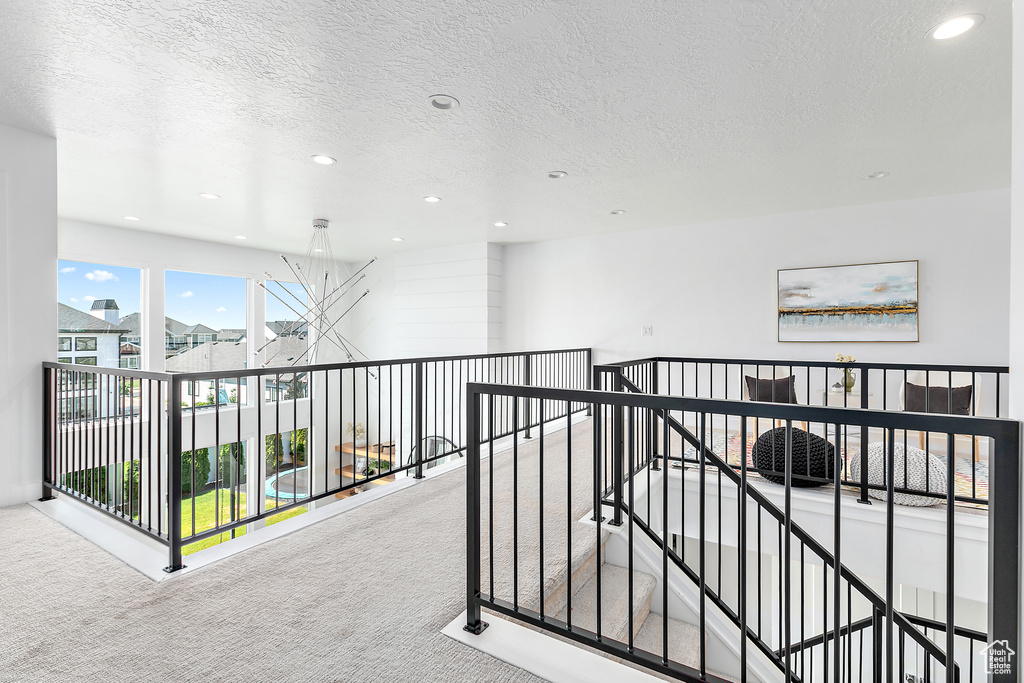 Hall with carpet, recessed lighting, and a textured ceiling