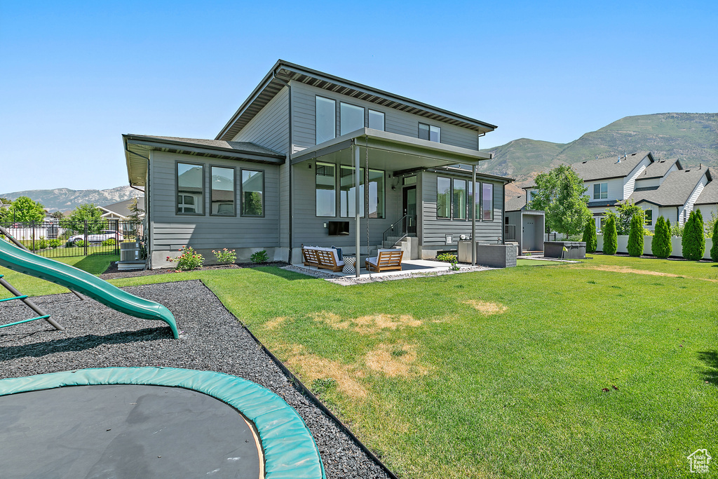 Rear view of house featuring a mountain view and a playground