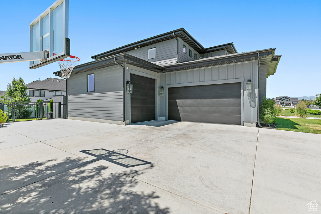 View of front of house featuring board and batten siding, concrete driveway, and a garage