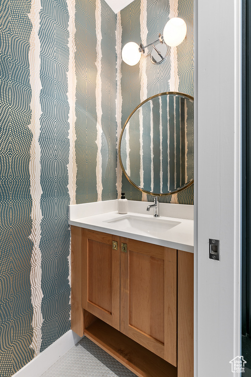 Bathroom featuring wallpapered walls and vanity