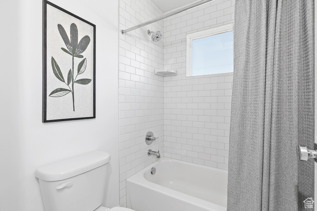 Bathroom with shower / tub combo and toilet