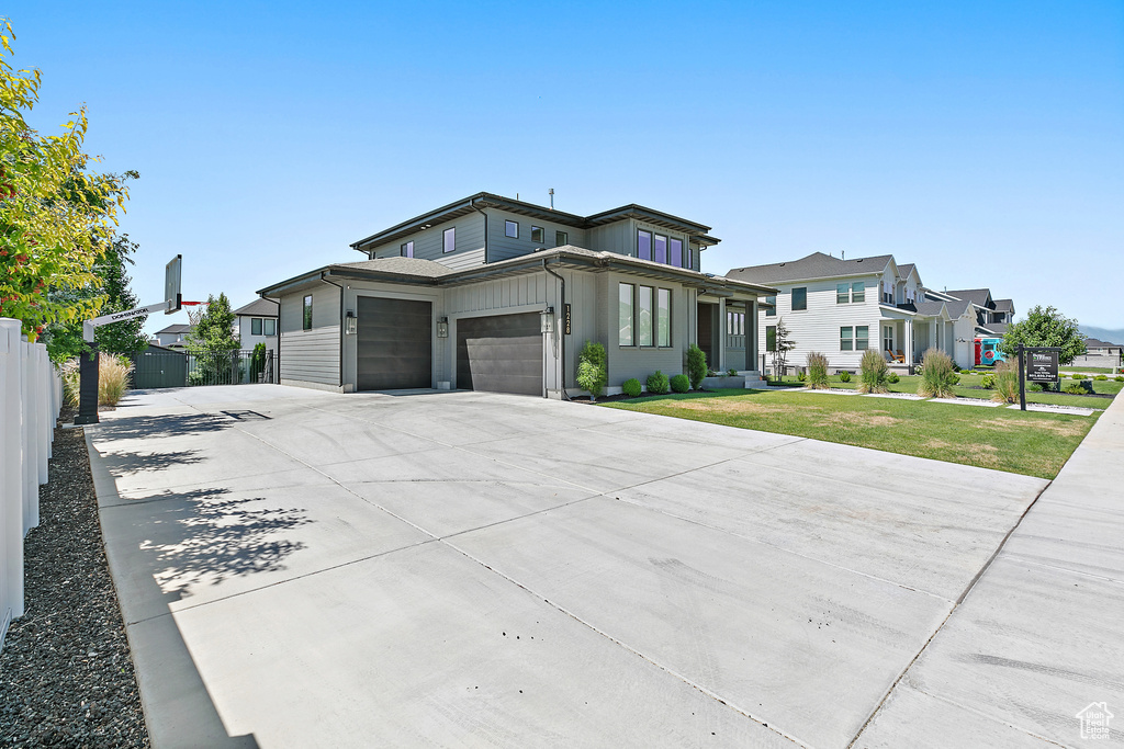 View of front facade with a residential view, driveway, and an attached garage