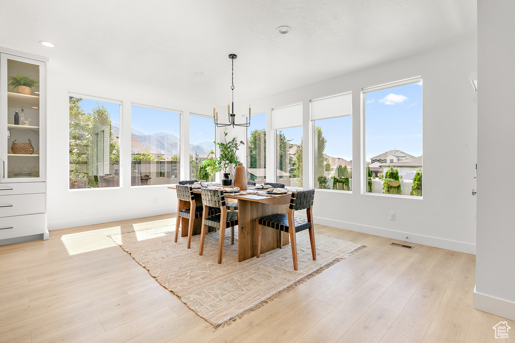 Dining space featuring a chandelier, light wood-type flooring, recessed lighting, and a mountain view