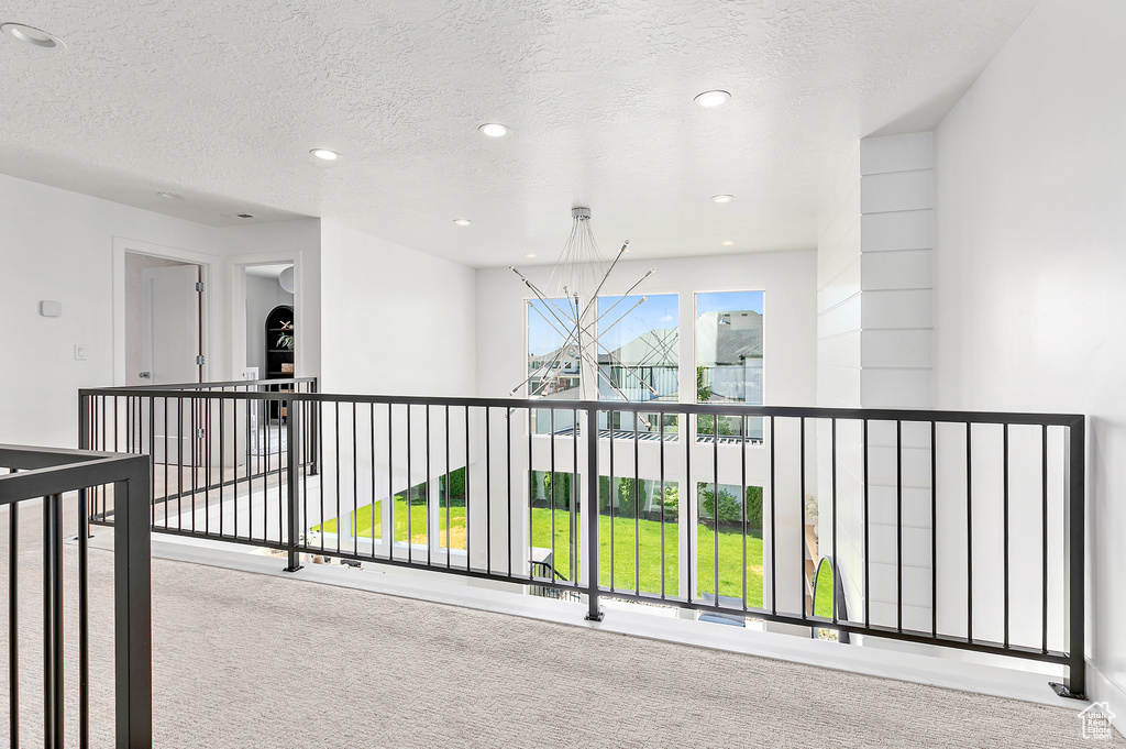 Hall featuring carpet, a chandelier, recessed lighting, and a textured ceiling