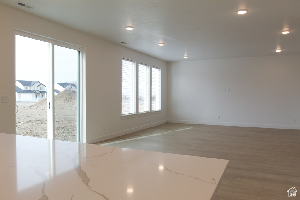 Spare room featuring baseboards, light wood-style floors, visible vents, and recessed lighting