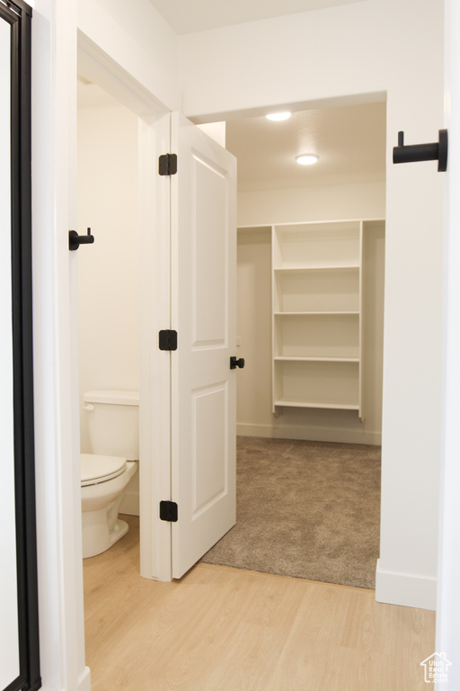 Walk in closet with light wood-style floors