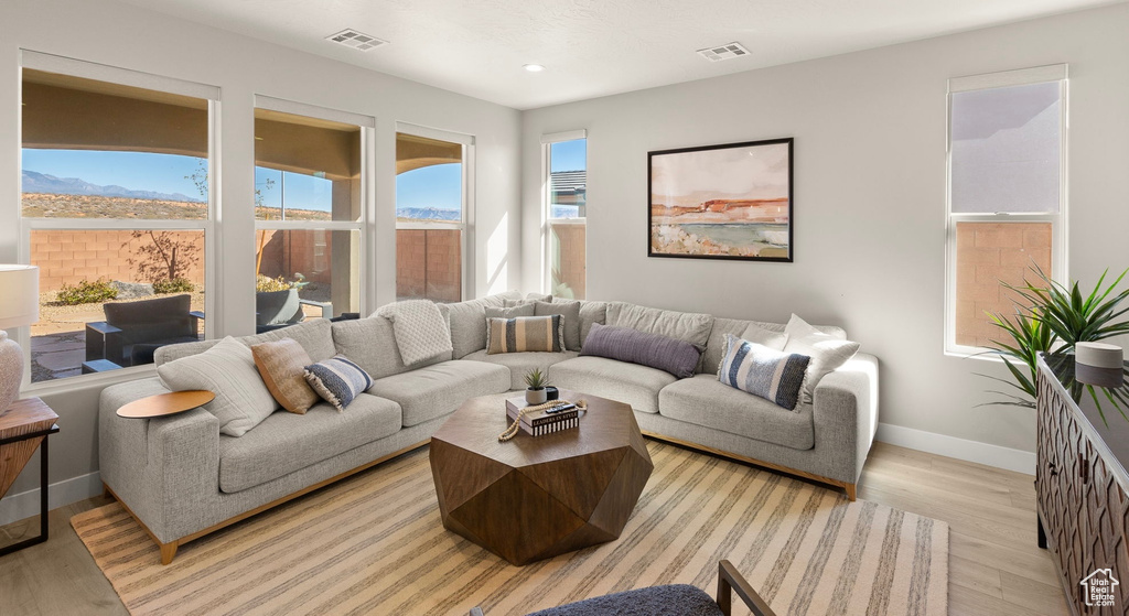 Living area featuring baseboards, light wood-style floors, and recessed lighting