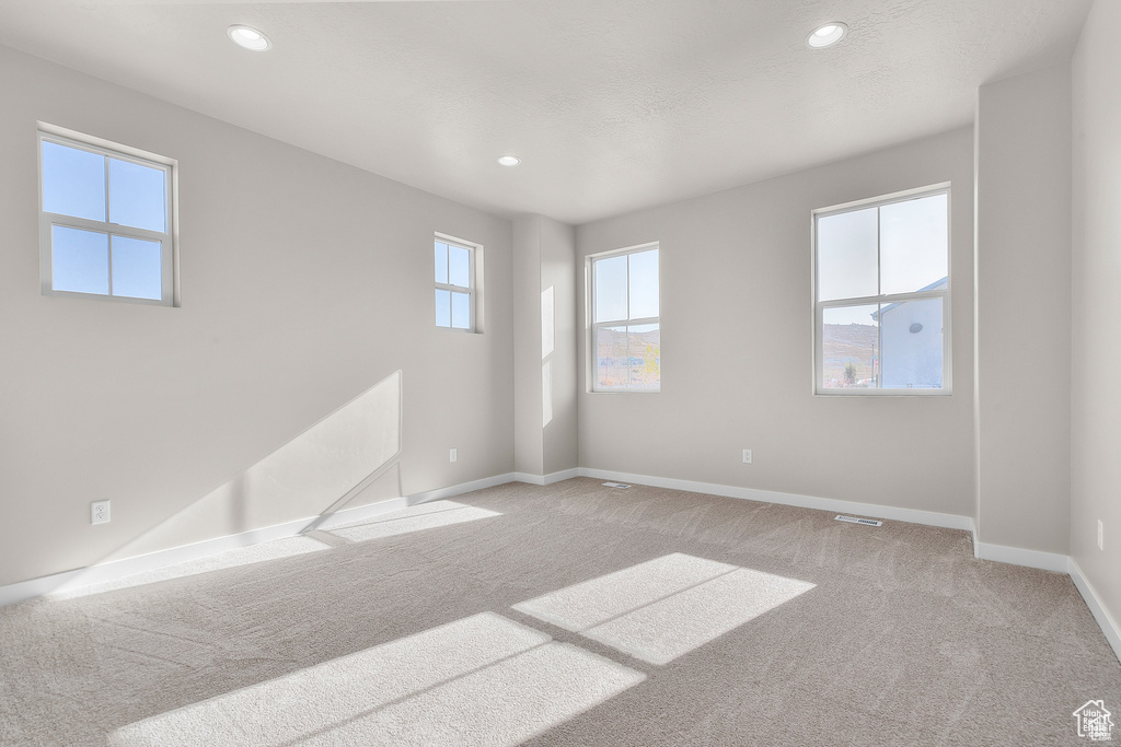 Spare room with light carpet, baseboards, and recessed lighting