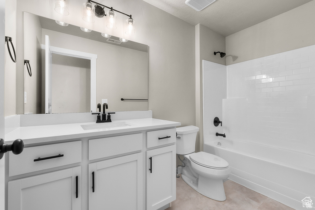 Bathroom featuring visible vents, toilet, vanity, tile patterned floors, and shower / bathtub combination