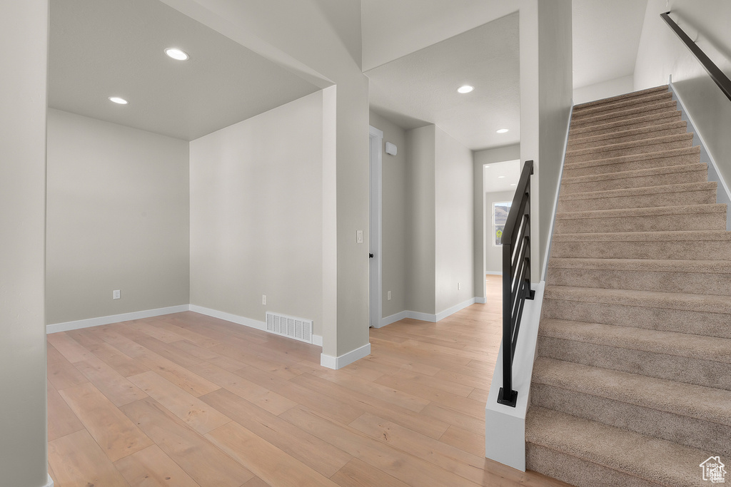 Staircase with baseboards, wood finished floors, visible vents, and recessed lighting